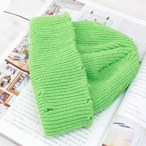 Detalle del gorro de punto verde brillante con efecto desgastado y textura de canalé fino