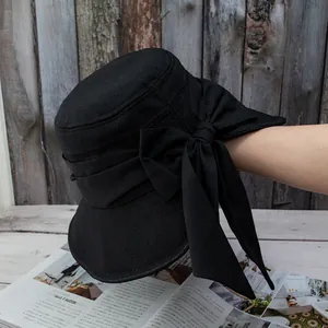 Detail of breathable mesh weave sun hat featuring a large elegant black satin bow
