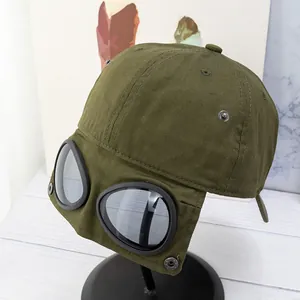 Détail de la casquette aviateur vert foncé avec lunettes intégrées et rivets métalliques