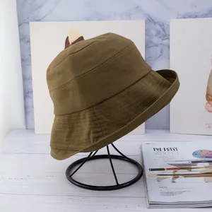 Detailed view of a brown cotton canvas bucket hat on a professional metal stand