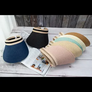 Multiple colors of straw sun visors stacked showing variety of textures and striped bands