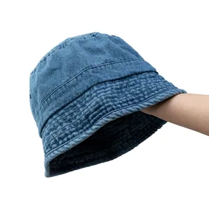 Handheld view of a vintage washed blue denim bucket hat with quilted brim detail