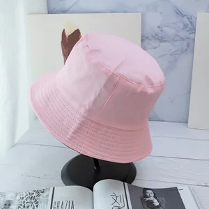 Detailed close-up of pink bucket hat stitching on canvas brim with a minimalist design