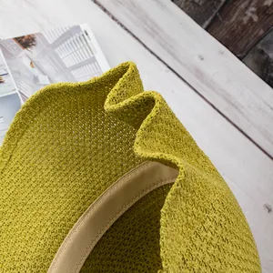 Detail of olive green knit bucket hat featuring intricate crochet texture and sweatband
