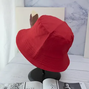 Detail of red cotton bucket hat with parallel stitched brim on professional display stand