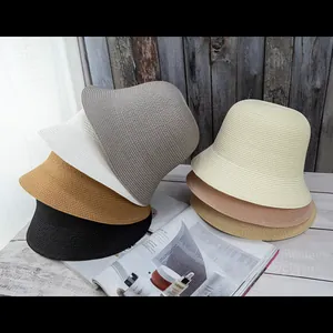 Collection of minimal woven straw bucket hats in various natural colors for summer