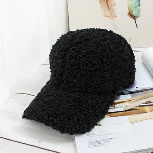 Close-up of black fleece baseball cap showing thick lamb wool texture on wooden table