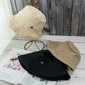 Foldable cotton bucket hats in beige, khaki, and black with a metallic M detail