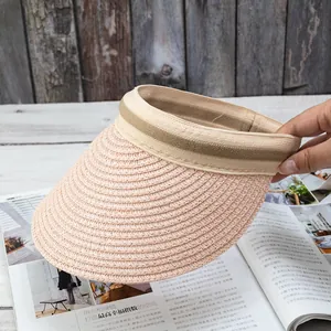 Detail of hand-woven straw visor hat with textured brim and dual-tone strap