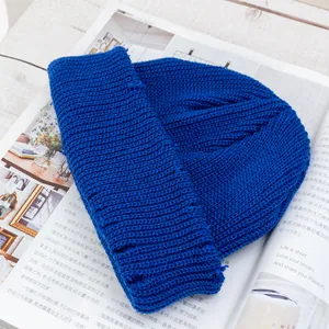 Detalle del gorro de punto azul real con diseño desgastado y textura de lana gruesa