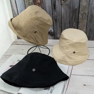 Foldable cotton bucket hat with M logo metal badge in khaki, black and beige colors