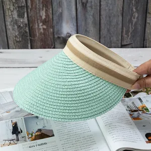 Detailed weave pattern of a mint green straw sun visor hat on a wooden background