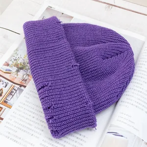 Primer plano detallado del gorro de punto morado sobre fondo de revista