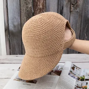 Detail view of tan knit equestrian sun hat with a ponytail opening and woven texture