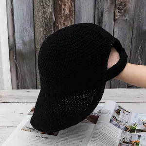 Detail of black knit ponytail baseball cap with breathable mesh and large rear opening