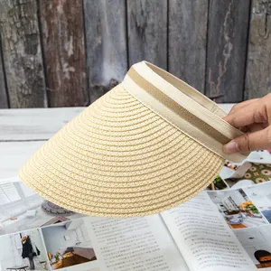 Detail of hand-woven straw visor featuring natural textures and decorative striped ribbon