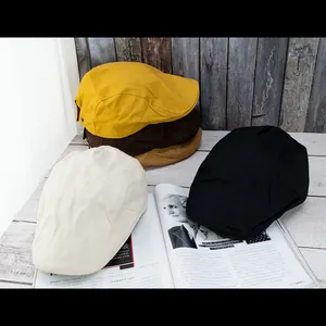 Retro style newsboy caps for women in various colors on a white wooden table
