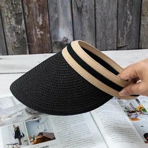 Detail of a black woven sun visor with striped trim on a vintage wooden background