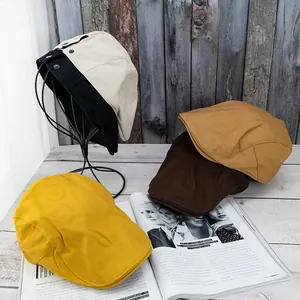 Flat cap display in multiple colors featuring vintage cotton stitching and button details