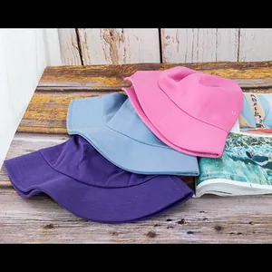 Gros plan de bobs en coton rose, bleu et violet avec œillets sur une table en bois