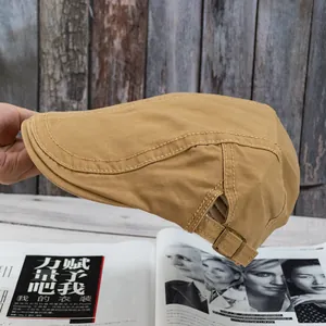 Detailed side view of khaki newsboy cap featuring metal buckle strap and twill cotton texture