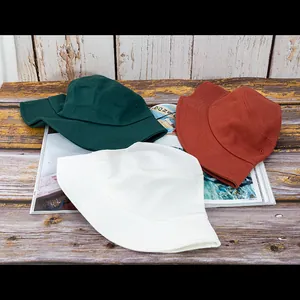 Détails de la texture des chapeaux de soleil en coton en vert, orange et blanc