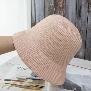 Detailed close-up of light pink woven straw bucket hat showing intricate spiral knit texture