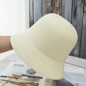 Detailed close-up of cream hand-woven straw bucket hat with textured sun protection fabric