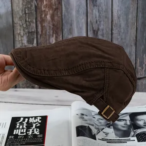 Detail of dark brown cotton newsboy cap with vintage metal adjustment buckle