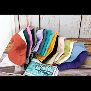 Détail de chapeaux bobs en coton multicolores sur un sol en bois rustique