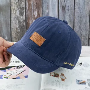 Détail de la casquette de baseball en coton bleu marine avec écusson en cuir vintage