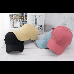 Klassische minimalistische Baseballkappen in vier Farben auf einer Holztischplatte