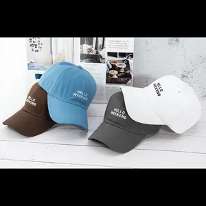 Detail of multi-color cotton baseball caps with Hello Weekend embroidery on wood surface