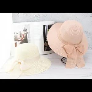 Chapeaux de paille d'été à larges bords avec grands nœuds en beige et rose doux