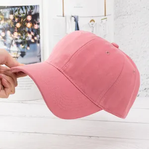 Detail einer rosa Baumwoll-Basecap mit Fokus auf die Nähte am Schirm und den oberen Knopf