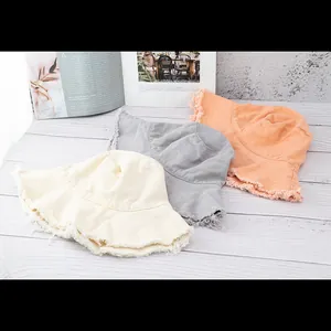 Japanische Fischerhüte mit Fransensaum in Beige, Grau und Orange auf Holzgrund