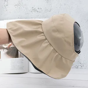 Detail of khaki sun visor with wide brim, wavy edges, and black UV-protective lining