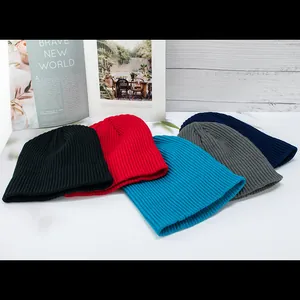 Detailed flat lay of five knitted beanies in black, red, blue, grey, and navy colors