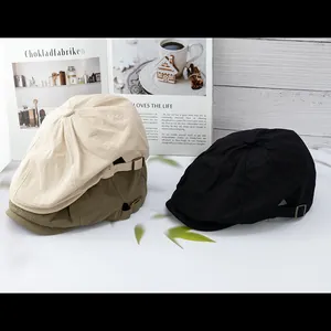 Detailed shot of vintage newsboy caps in beige, olive, and black with metal side buckles