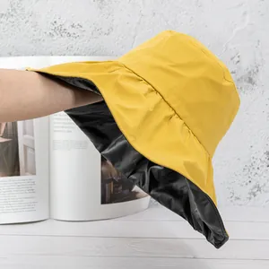 Detail of wide brim sun hat showing yellow outer fabric and black inner lining