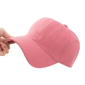 Minimalistische rosa Baumwoll-Baseballkappe mit gebogener Krempe in der Hand gehalten