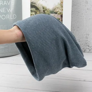 Detail showing the elastic waffle texture and soft blue-grey knit fabric of the beanie