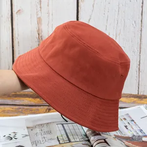 Détail d'un chapeau bob en toile de coton rouge brique avec large bord surpiqué pour le soleil