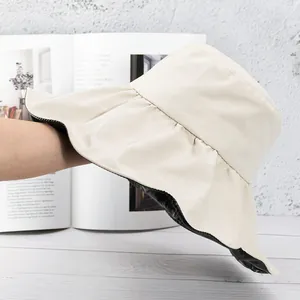 Detail view of double-sided beige sun hat with black UV protection lining and wide brim