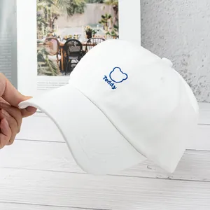 Close-up of white canvas baseball cap featuring blue Teddy bear embroidery detail