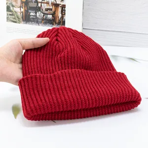 Detail of red rib-knit beanie showing thick texture and soft woolen fabric