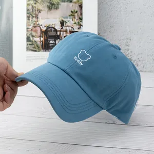 Close-up of navy cotton baseball cap featuring white Teddy bear head embroidery detail