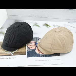 Detail of vintage cotton canvas newsboy hats in black and khaki colors on a magazine