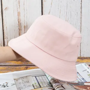 Détail d'un chapeau bob en coton rose clair montrant les coutures du bord et les œillets