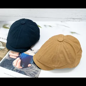 Detail of navy blue and yellow newsboy caps with visible stitching and top button